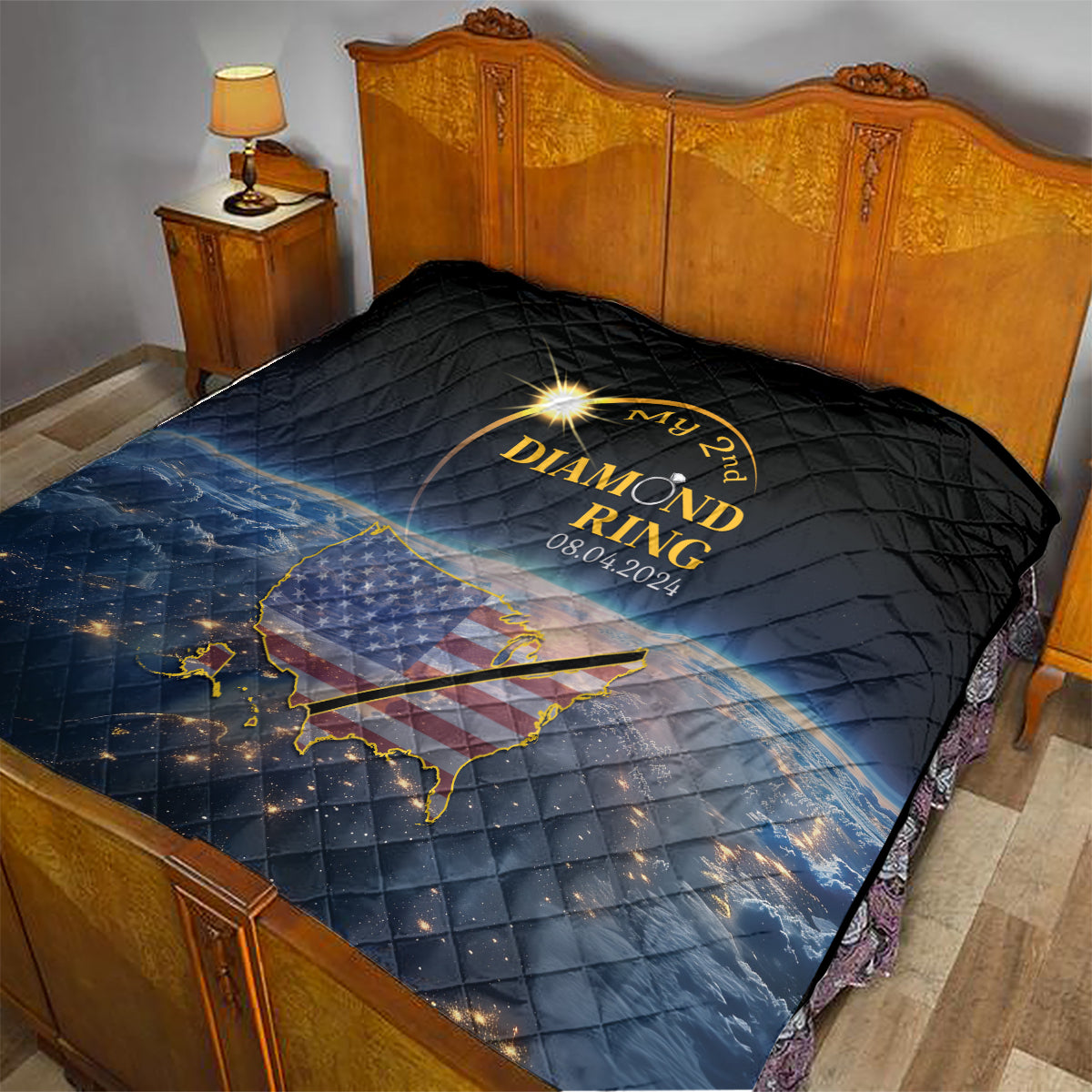 Black quilt with gold diamond ring design, date, and US map graphic over bed