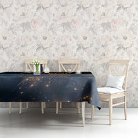 Black tablecloth with gold and orange space artwork, spread over dining table