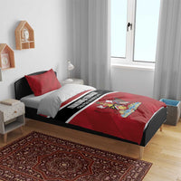 Red duvet cover and pillow shams with black/white stripe and crest graphic on bed