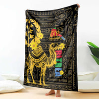 Black blanket with gold camel and floral pattern, Enkutatash logo and multicolor blocks