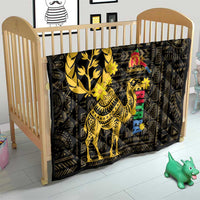 Black baby quilt with yellow camel illustration and colorful motif, on a crib