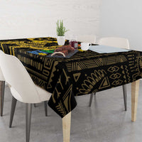 Black and gold patterned tablecloth covering a dining table with chairs