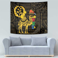 Black wall tapestry with gold camel silhouette, flower accents, and geometric frame