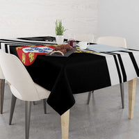 Black tablecloth with black-and-white striped bands and crest design, on dining table.