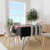Black tablecloth draped over dining table with black-and-white stripe bands and crest.