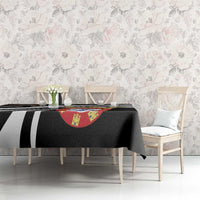 Black tablecloth covering dining table with black-and-white stripes and crest centerpiece graphic.