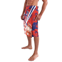 Red and blue hibiscus print swim shorts with crest graphic and white diagonal stripe