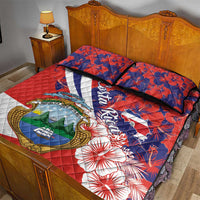 Red quilt bed set with blue hibiscus print, coat of arms, and matching pillow