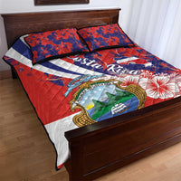Red quilt bed set showing coat of arms, blue floral accents, and quilt stitching