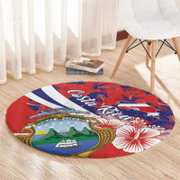 Round red area rug with Costa Rica emblem, hibiscus pattern, and navy-blue diagonal band
