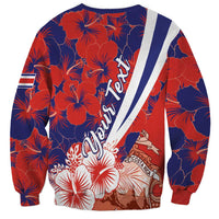 Red and navy sweatshirt with diagonal white stripe, hibiscus pattern, and crest detail