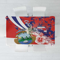 Red tablecloth with blue hibiscus flowers and crest motif