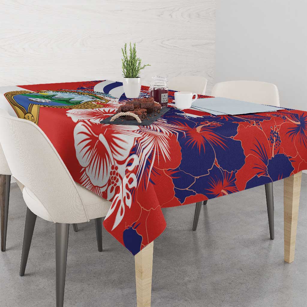Red and blue hibiscus tablecloth with crest and floral accents on dining table