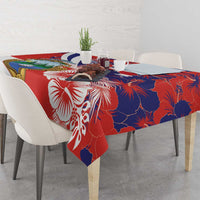 Red and blue hibiscus tablecloth with crest and floral accents on dining table