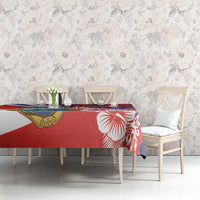 Red hibiscus tablecloth with crest emblem on dining table