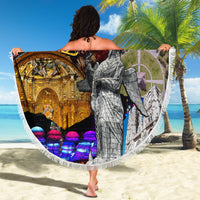 Round beach blanket with white fringe and 'Fiestas de Quito' collage, wrapped around woman on sand