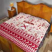 Red and white Alabama Christmas quilt laid on a bed, featuring Santa icons and Alabama text