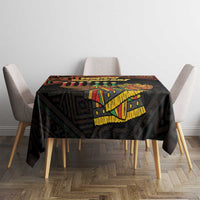 Black Kwanzaa tablecloth with 'Happy Kwanzaa' text and African pattern border on top.