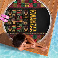 Round beach blanket laid flat, black center with colorful African Kwanzaa pattern and tassel fringe