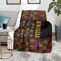 Kwanzaa African pattern blanket folded on a couch, black with colorful blocks and KWANZAA lettering