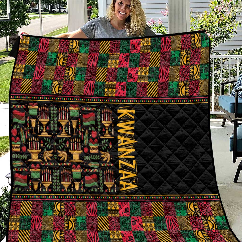 Kwanzaa quilt with black quilted center, multicolor geometric bands and 'KWANZAA' text