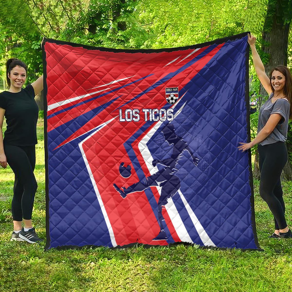 Red and blue quilt blanket spread on grass, Los Ticos soccer design