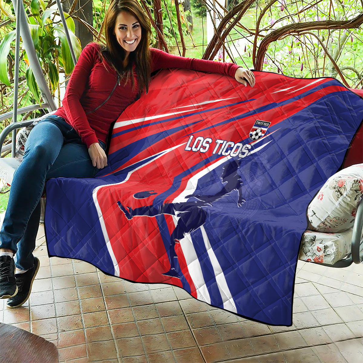 Red and blue quilt blanket draped over couch, Los Ticos soccer silhouettes