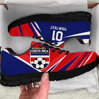 Blue and red soccer sneakers with black sole and black laces, outsole close-up
