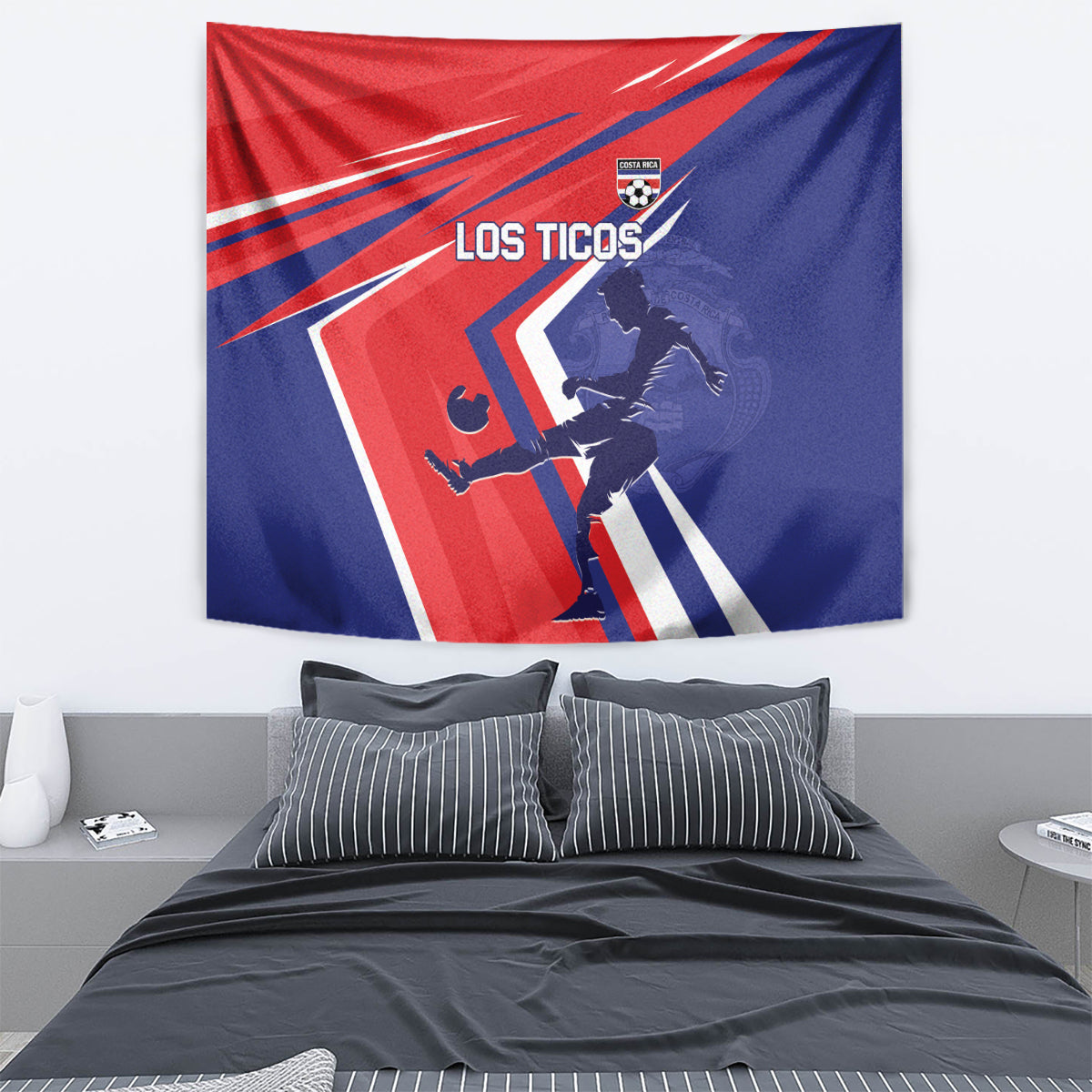Costa Rica soccer tapestry on wall above bed, red and blue 'LOS TICOS' player artwork