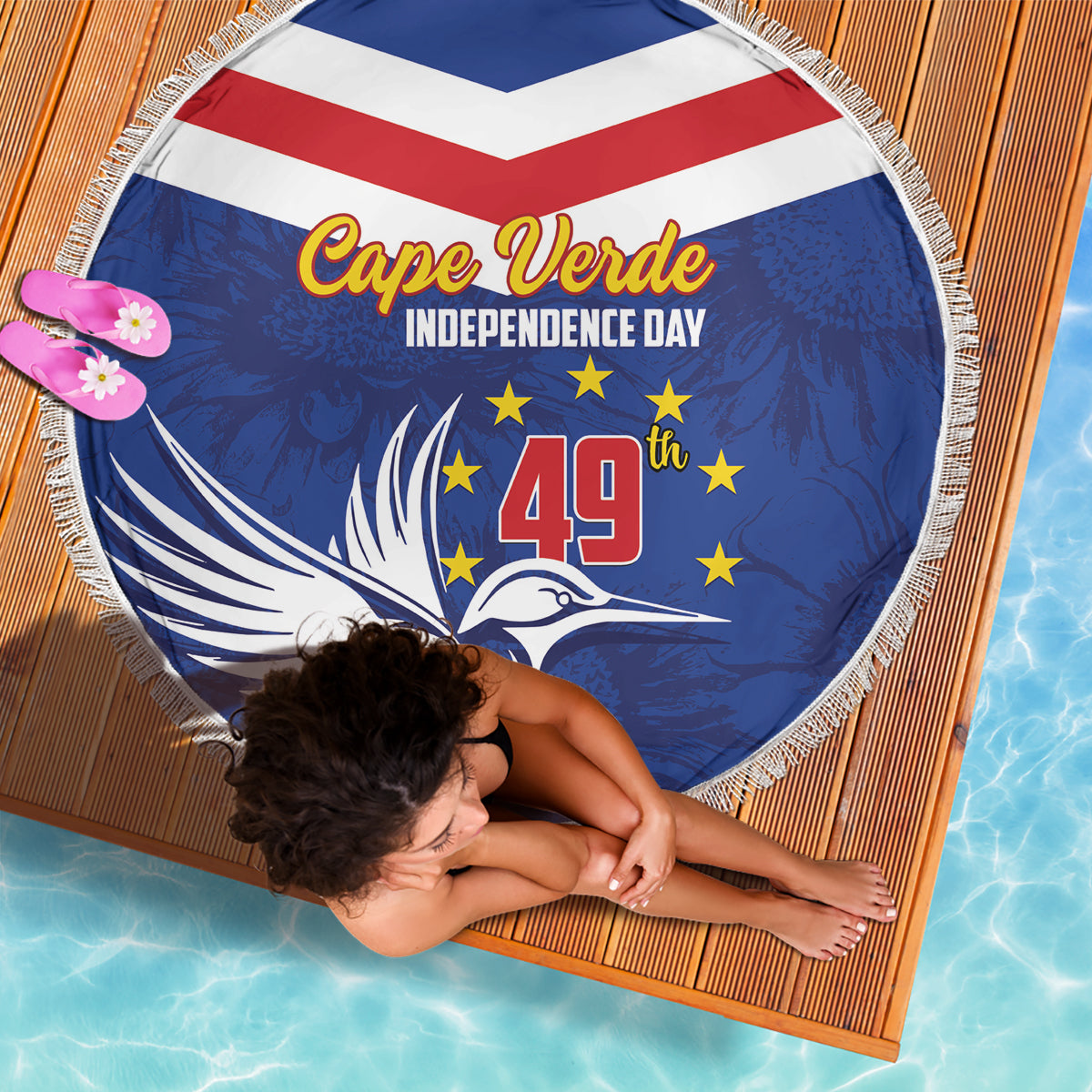 Round blue beach blanket with fringed edge and bold Cape Verde Independence Day graphic