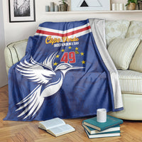 Blue independence day blanket with chevron stripes and dove graphic, draped over a sofa