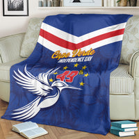 Blue independence day blanket with chevron stripes and dove graphic, laid on a couch
