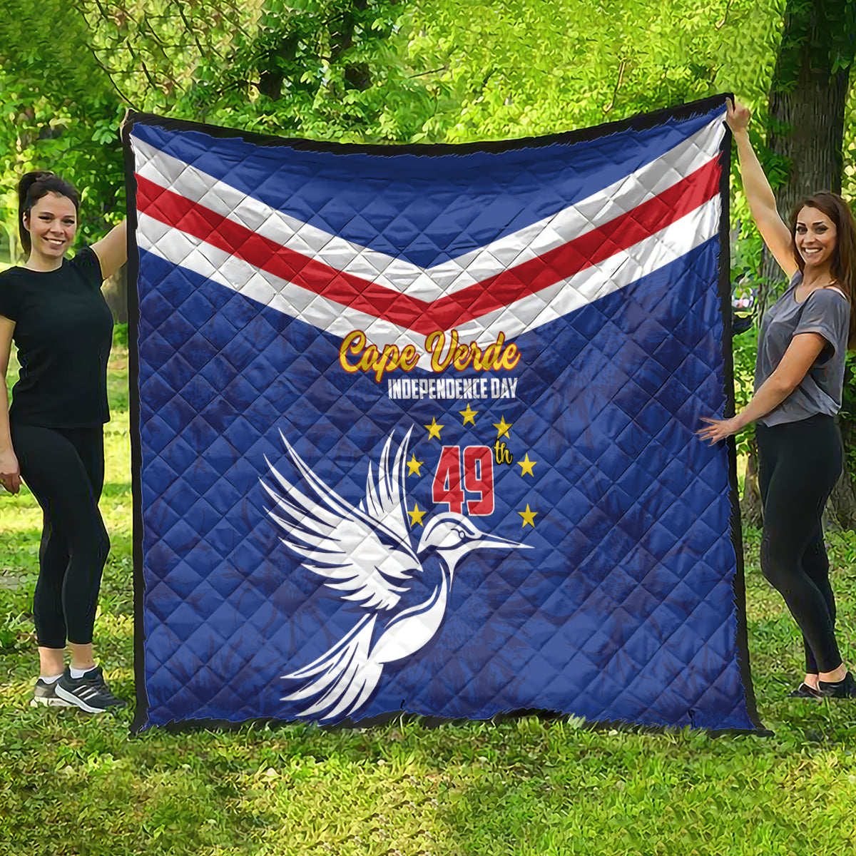 Blue Cape Verde Independence Day quilt held outdoors with flag stripes, stars, and bird graphic