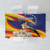 Vibrant blue tablecloth with red and yellow stripe rays, flowers, and troupial bird