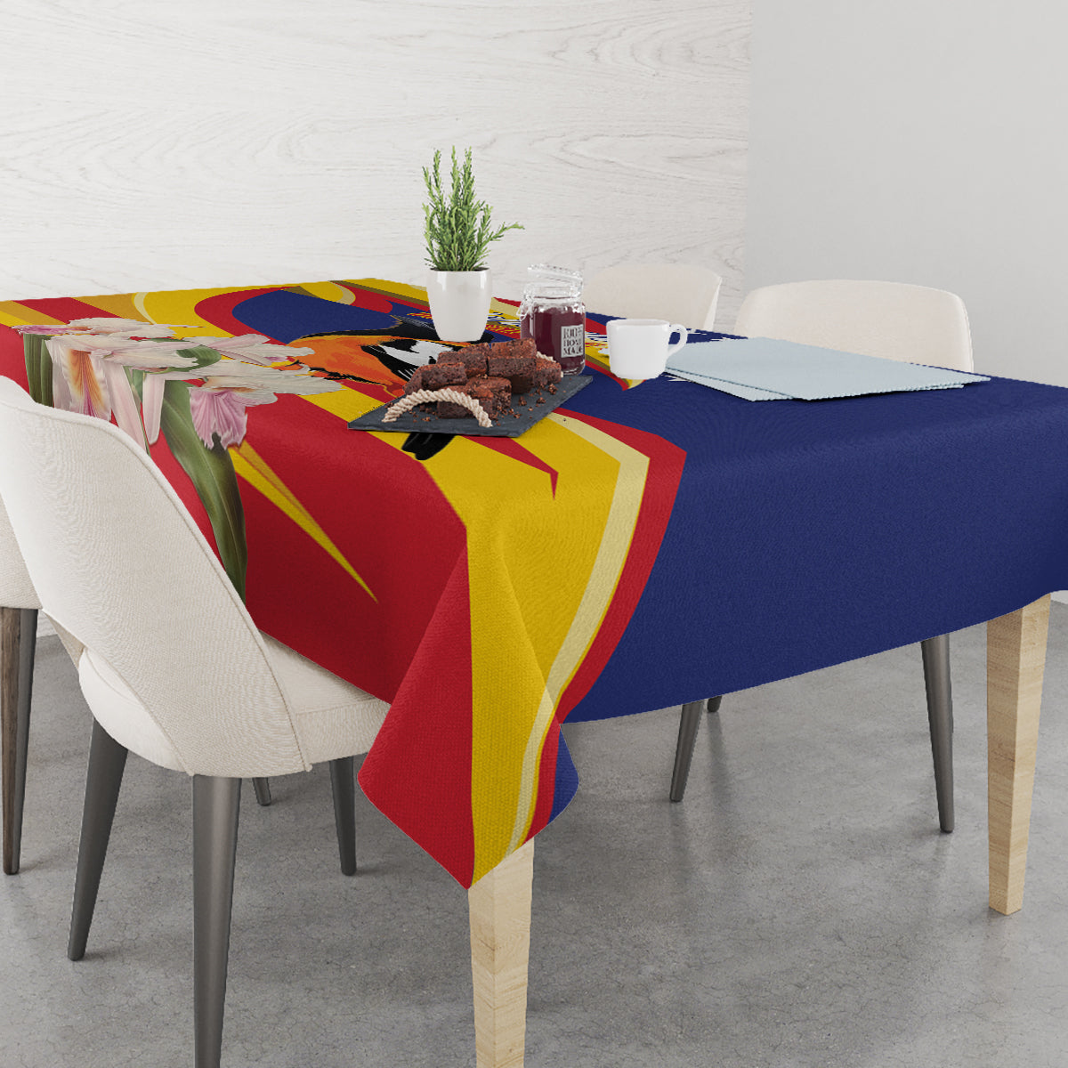 Blue and multicolor tablecloth with floral and bird design across dining table