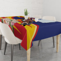 Blue and multicolor tablecloth with floral and bird design across dining table