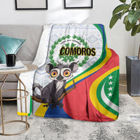Comoros flag-themed blanket on floor with lemur graphic, laurel emblem, and red/green/blue colors.