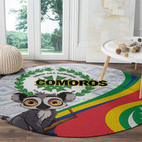 Round rug with COMOROS text, cartoon lemur and rainbow flag stripes, green wreath graphic