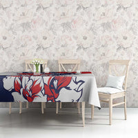 Red, blue, and white eagle motif tablecloth on a dining table with chairs.