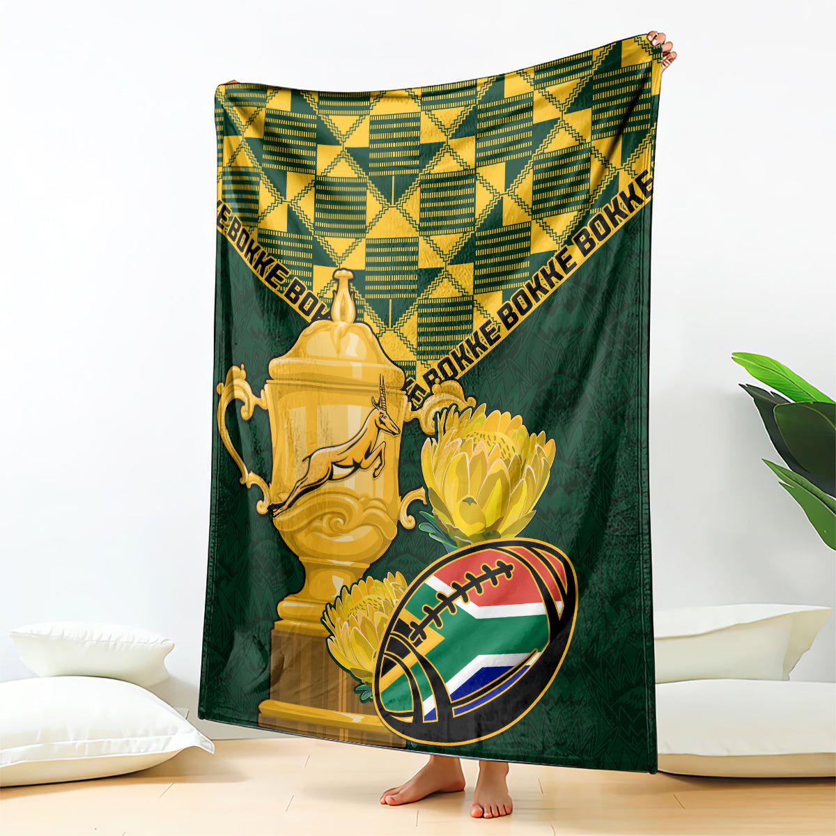 Green rugby blanket with gold trophy, ball graphic, and Bokke text border