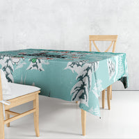 Turquoise tablecloth with black cat silhouettes and paw-print pattern, draped over a table