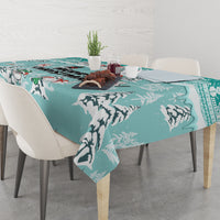 Turquoise tablecloth with large cat silhouettes and winter tree motif, draped on dining table