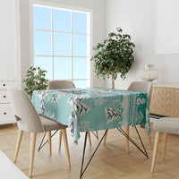 Turquoise tablecloth with cat silhouettes and Christmas border, on dining table with chairs