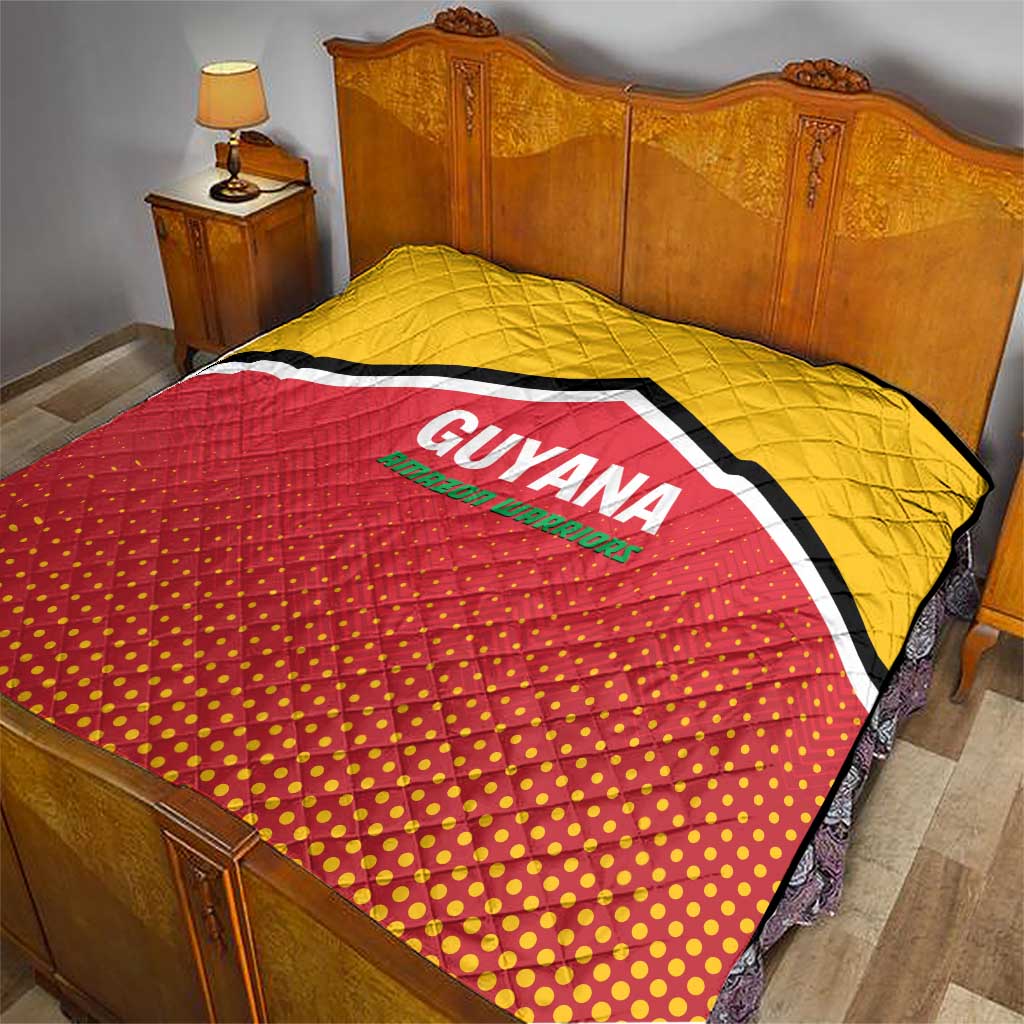 Quilt on a bed with yellow upper section, red dotted lower section, and GUYANA logo