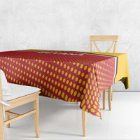 Red and yellow dotted cricket tablecloth with black trim, over bench table