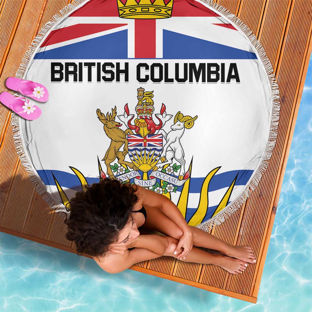 White round beach blanket with British Columbia flag crest, fringed border, angled view