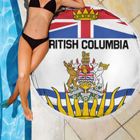 White round beach blanket with British Columbia crest, fringed edge, draped near pool
