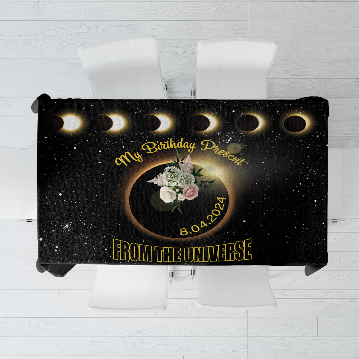 Black tablecloth with solar eclipse graphic, gold rings, and birthday message design
