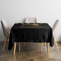 Black square tablecloth with solar eclipse gold rings and centered birthday-themed print