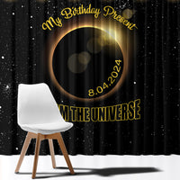 Close-up black window curtain with gold eclipse circle graphic and “FROM THE UNIVERSE” text